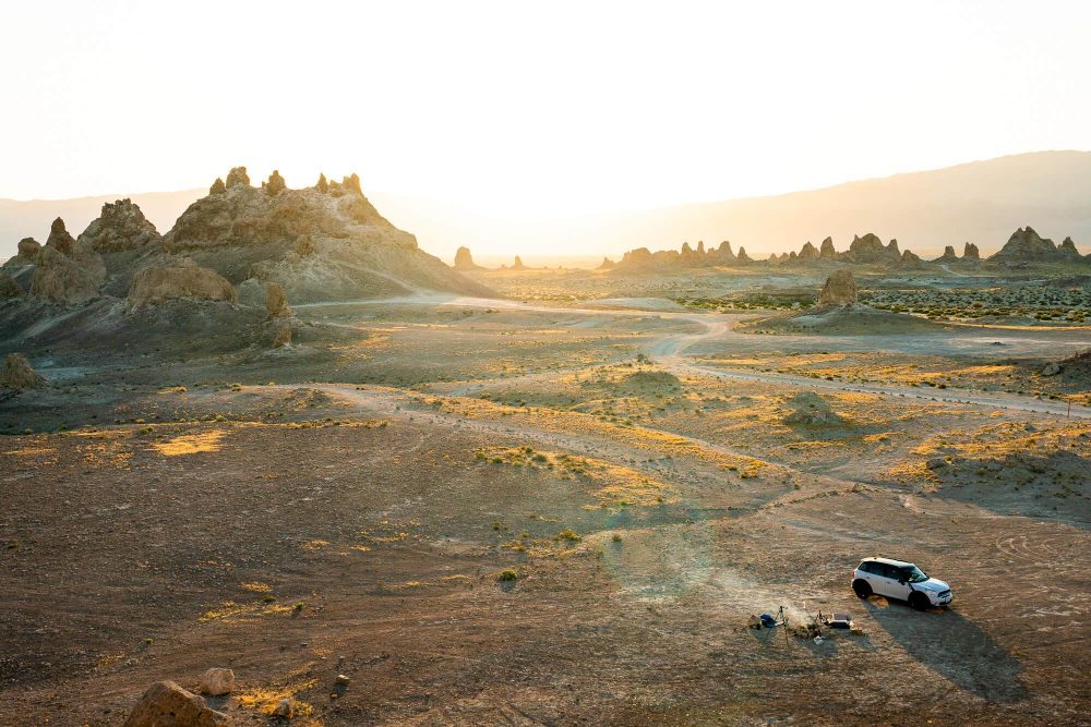 smoldering fire next to mini countryman during sunrise at trona pinnacles in california | photo by jake landon schwartz